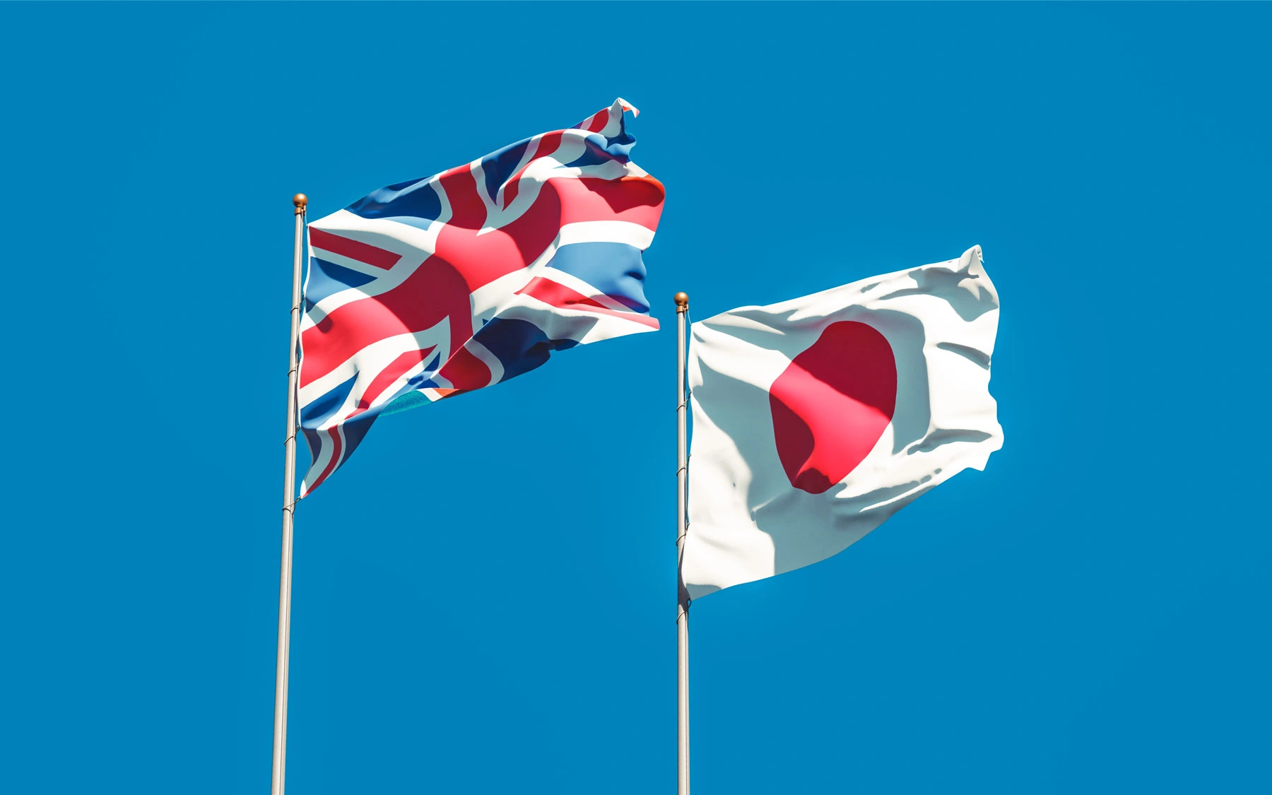 Flagi Wielkiej Brytanii i Japonii jako symbol rynków stosujących metody ograniczania ryzyka związanego z paleniem tytoniu.